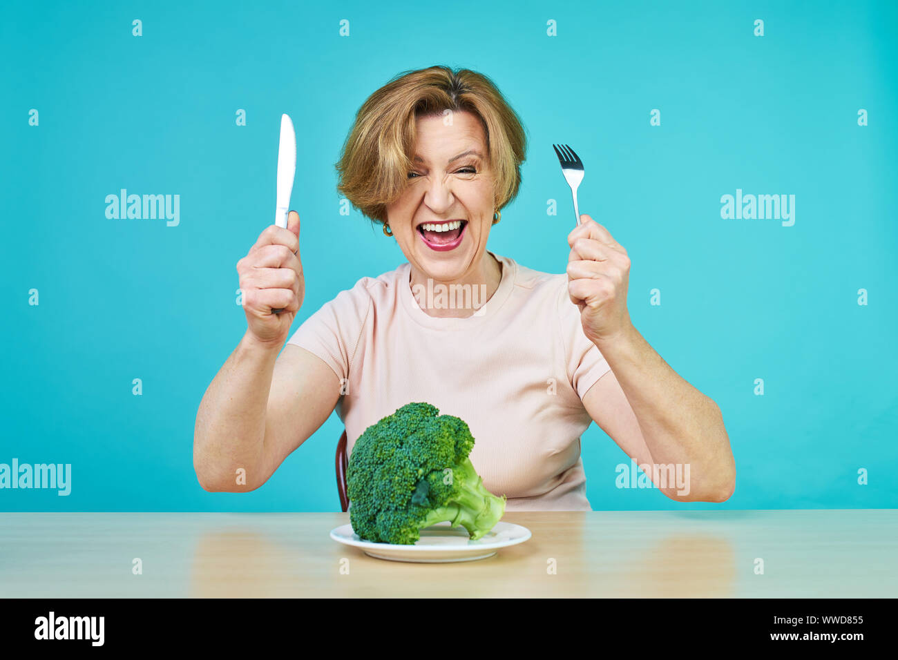 An aged woman is about to eat a vegetarian dish. Funny old woman on a