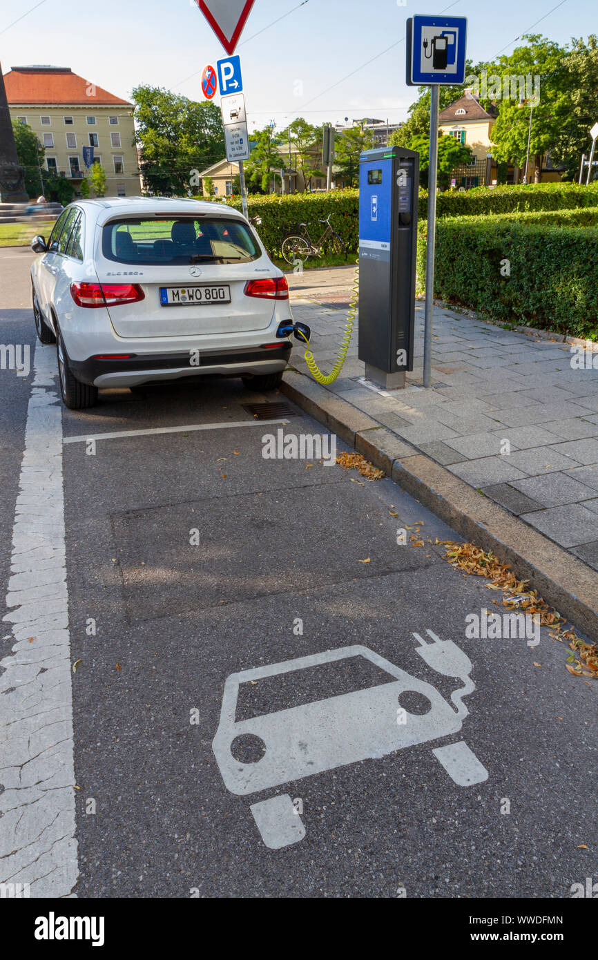 Car on charge at a SWM road side charging point in the centre of Munich