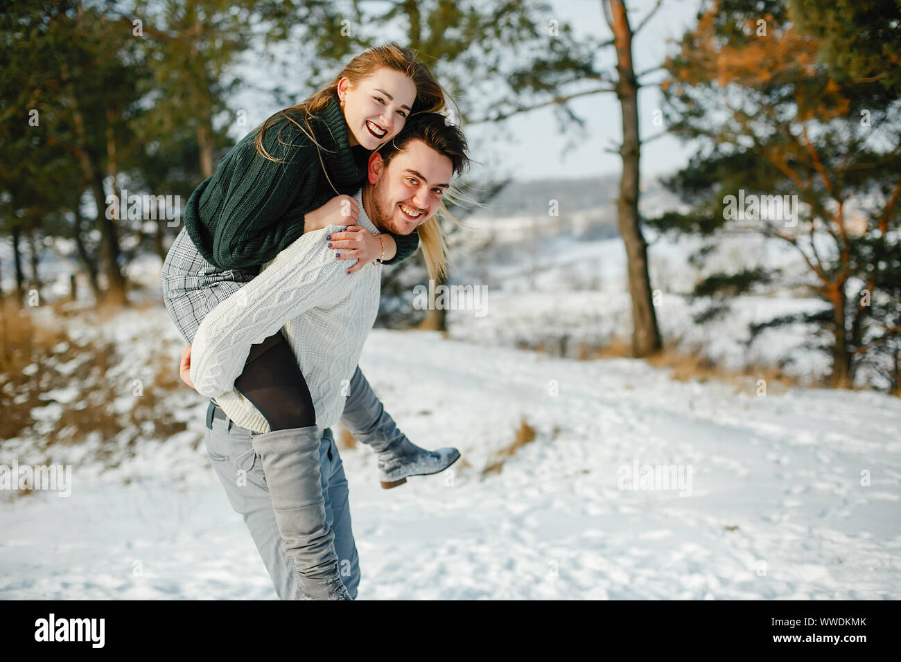 happy couple kissing and hugging in the park on a snowy winter day ...