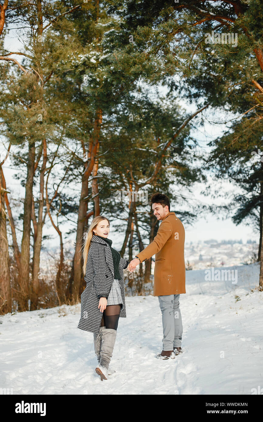 happy couple kissing and hugging in the park on a snowy winter day ...