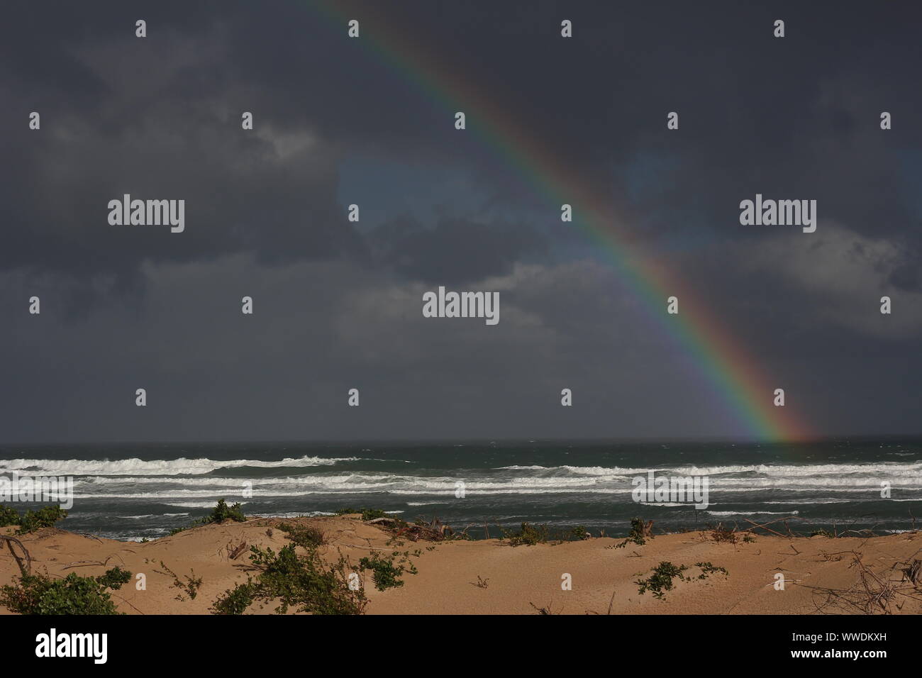 Rainbow over the Indian Ocean at Cannon Rocks, Eastern Cape, South Africa Stock Photo