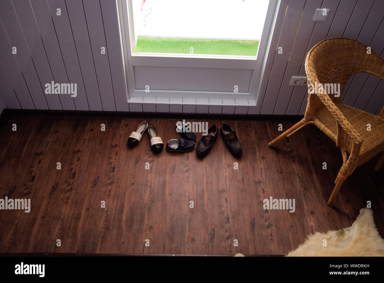 Shoes near the door in the hallway. Hallway in the house. Stock Photo