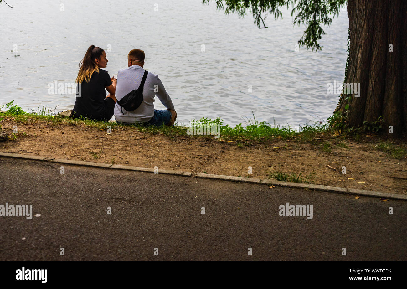Back view of two youngers standing near a lake in Bucharest, Romania, 2019. Stock Photo