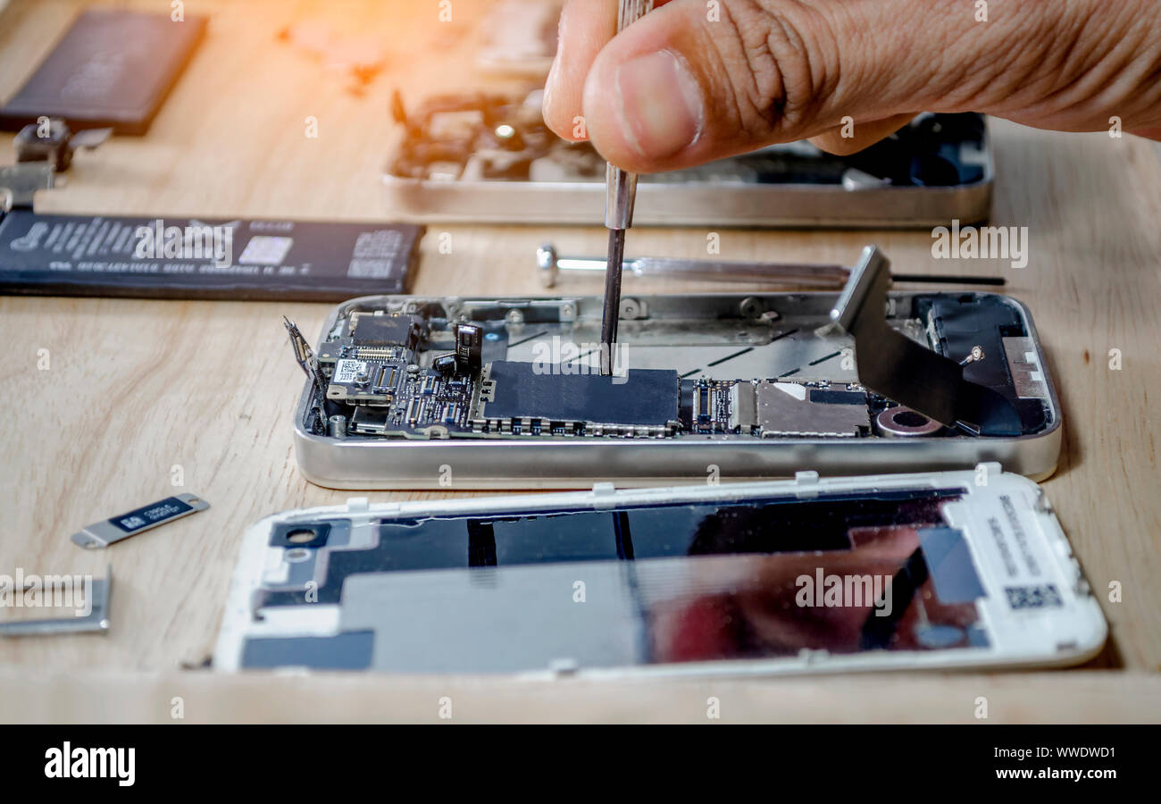Iphone motherboard repairs into the motherboard for smartphone By  professional technician on desk Stock Photo - Alamy