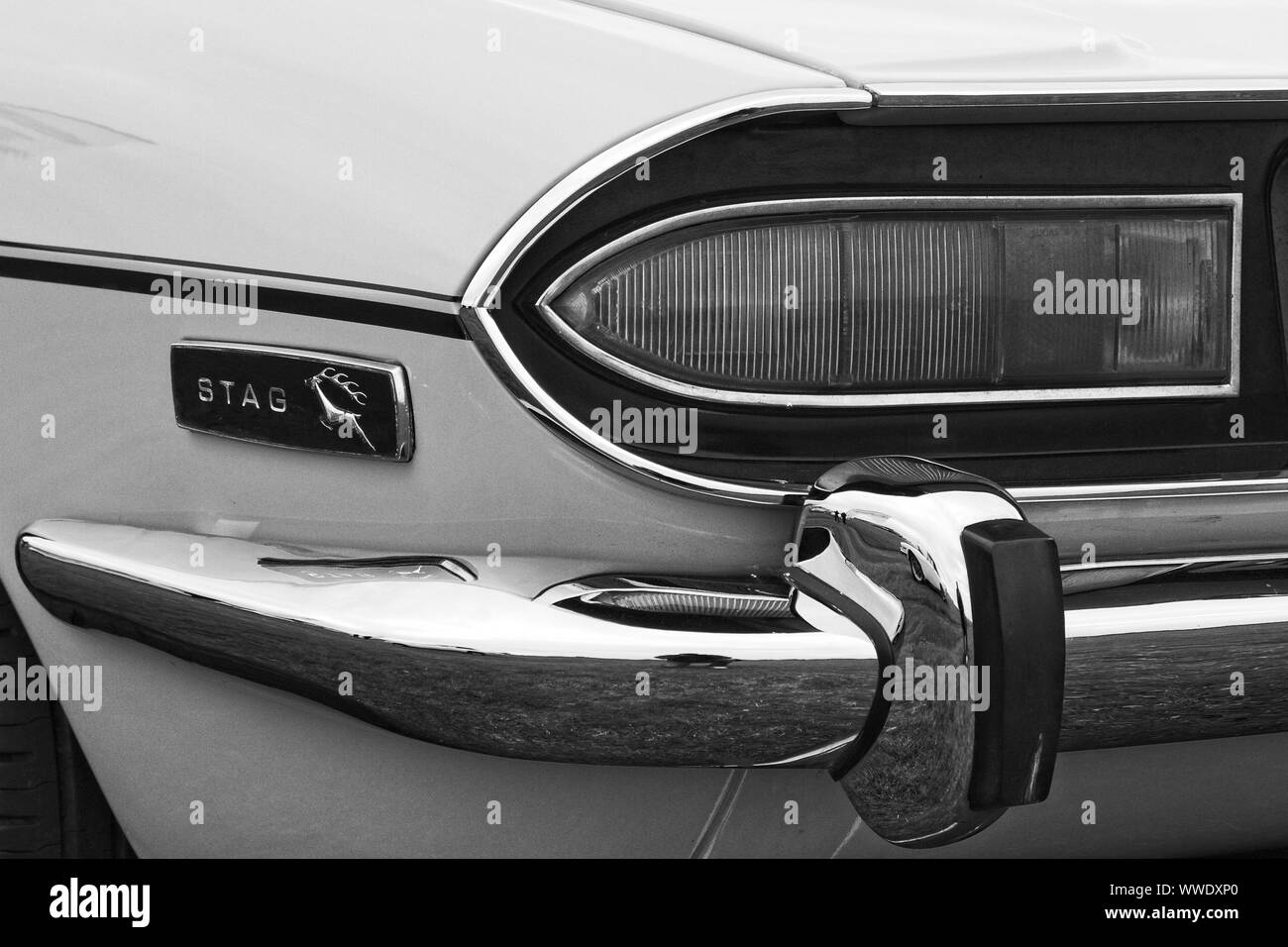 Left side rear quarter detail of a Triumph Stag classic British sports car showing chrome bumper, light cluster and Stag badge. Stock Photo