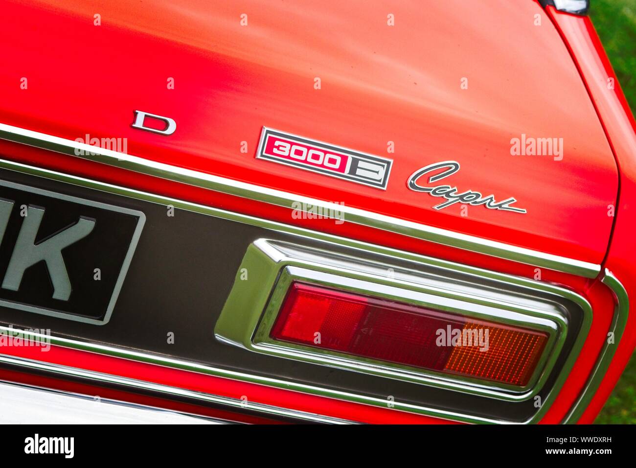 Right rear quarter detail of a sunburst 1970's Ford Capri 3000E showing badge and rear light cluster. Stock Photo