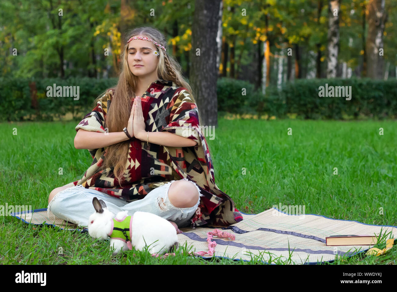 hippie girl meditation yoga in the park  vintage rabbit pet Stock Photo
