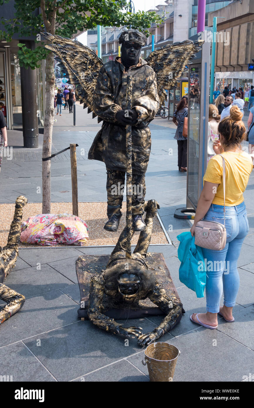 Gravity defying floating angel living statue street artist performing