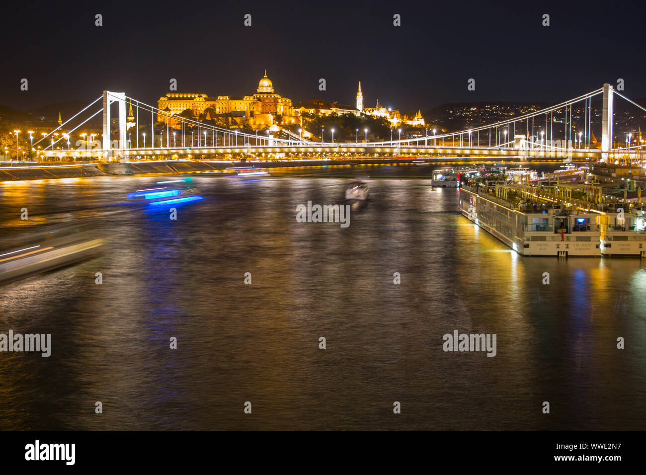 Long exposure of Budapest chain bridge with boat lights moving underneath Stock Photo