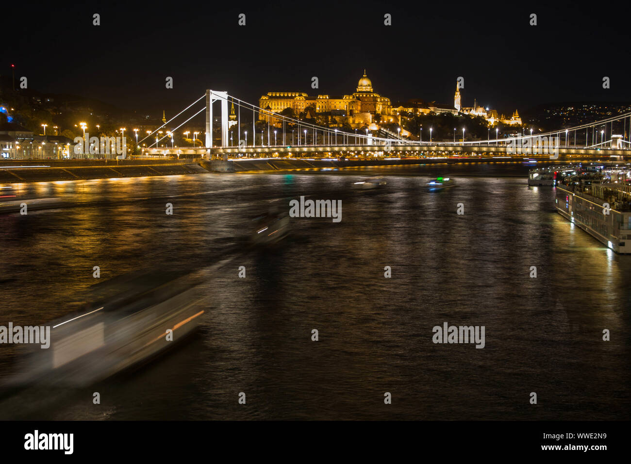 Long exposure of Budapest chain bridge with boat lights moving underneath Stock Photo