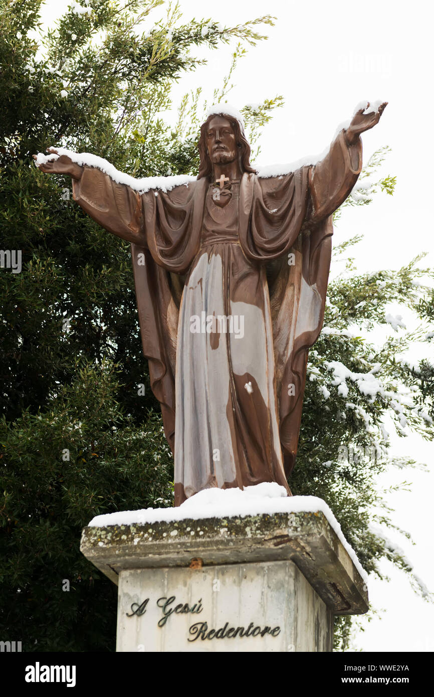 A statue of Jesus Christ covered in snow in Piazza Giovanni XXIII Avetrana, Italy Stock Photo