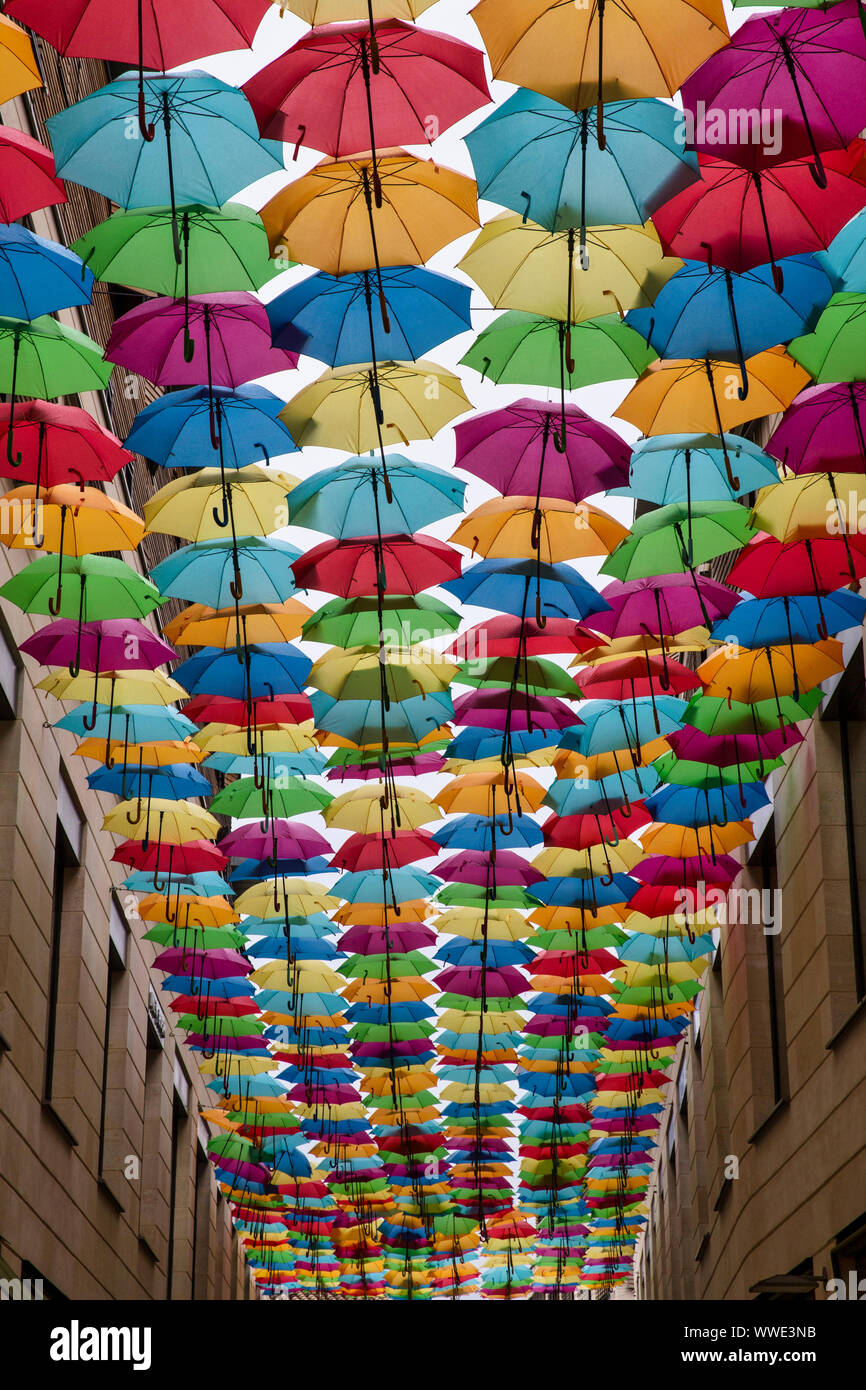 Overhead umbrella display in side street Bordeaux Stock Photo