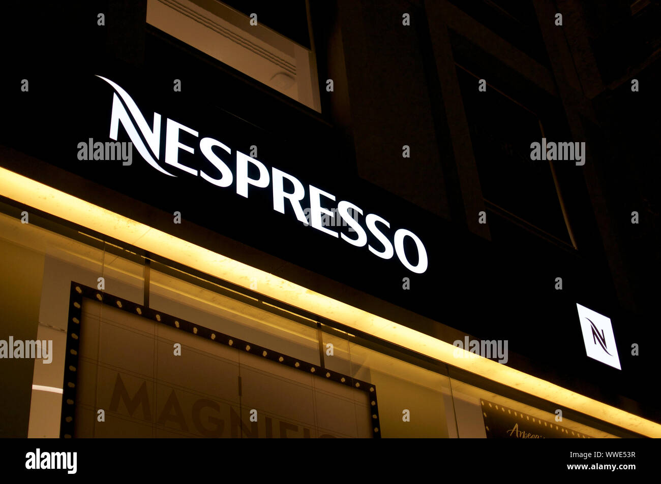 Milano, Lombardy, Italy - 11th September 2019 : View of a illuminated Nespresso Logo hanging in front of a store in Milano, Italy. Nespresso is famous Stock Photo