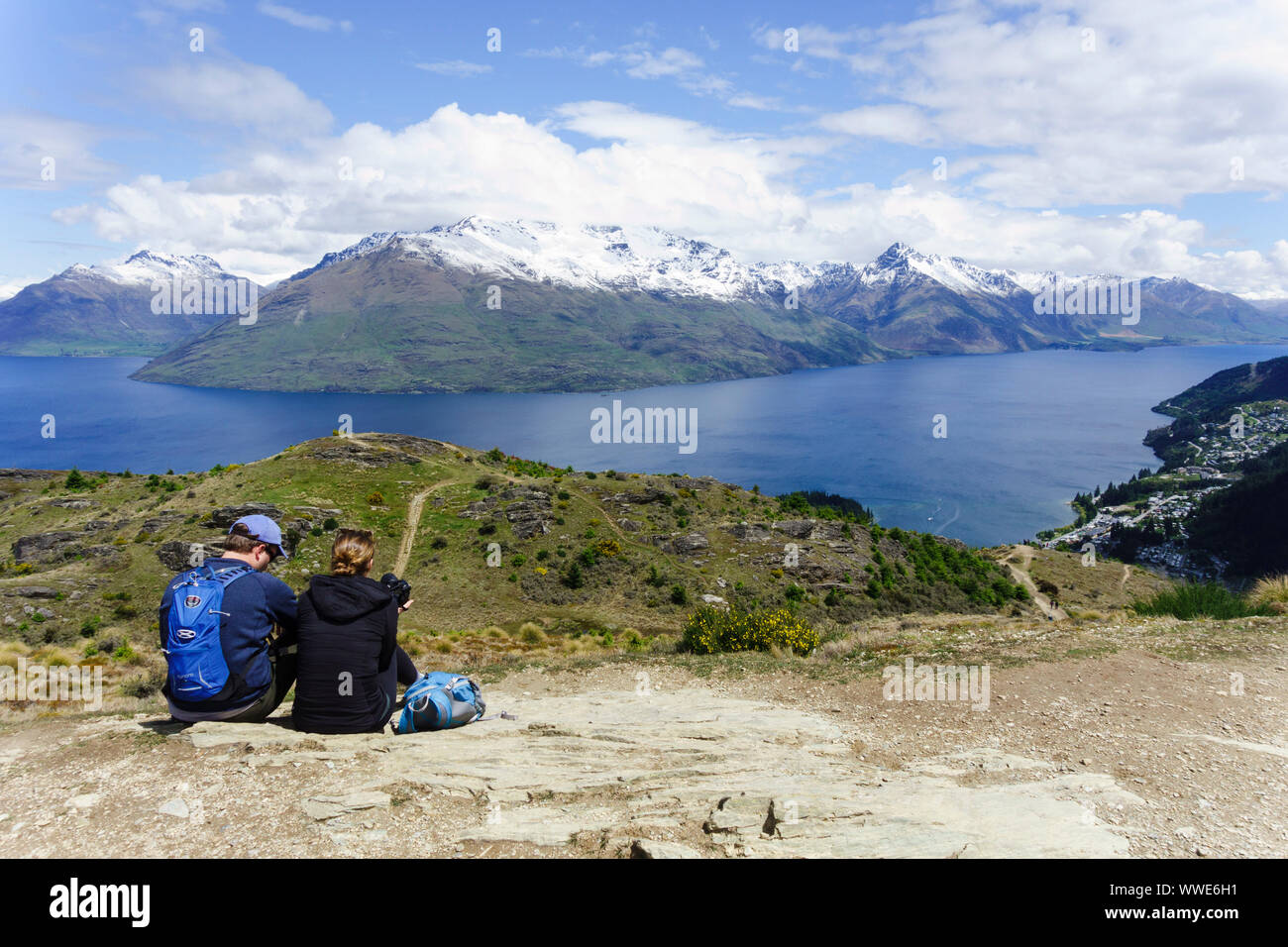 Couple enjoying the view over Lake Wakatipu from Queenstown Hill. Queenstown, Otago, New Zealand. Stock Photo