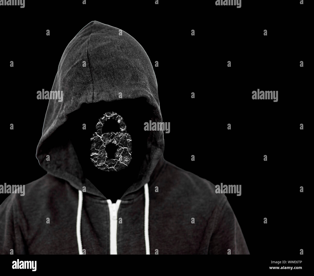 Hooded menacing man with unseen face wearing a black top with a computer lock which has been broken by the hackers criminal work Stock Photo