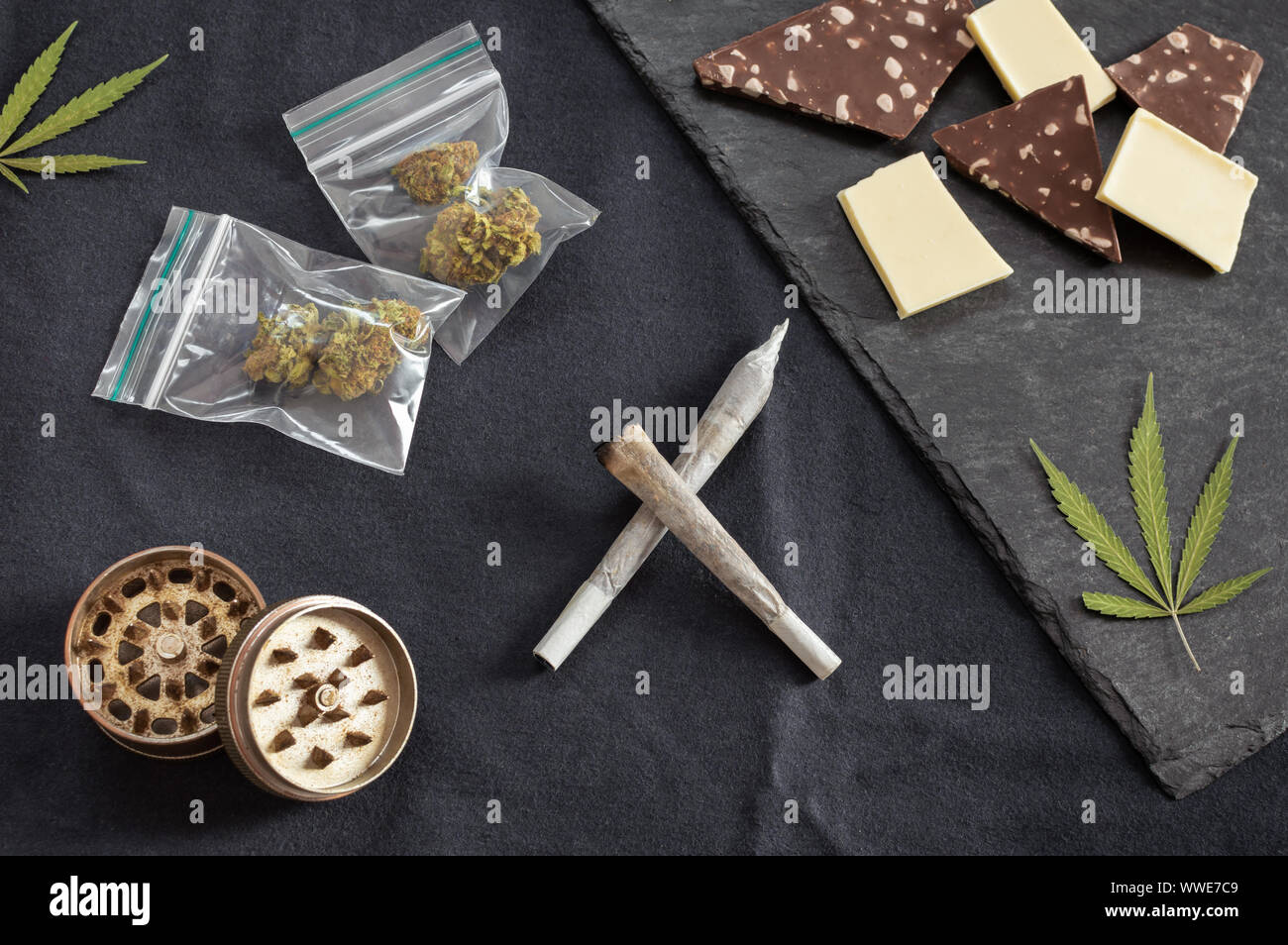 Weed and sweets joints, marijuana leaves, buds on plastic bag and