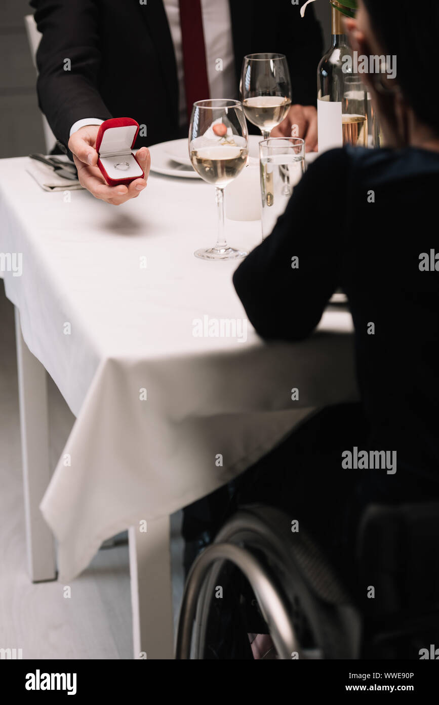 partial view of boyfriend making wedding proposal to disabled young woman while having romantic dinner Stock Photo