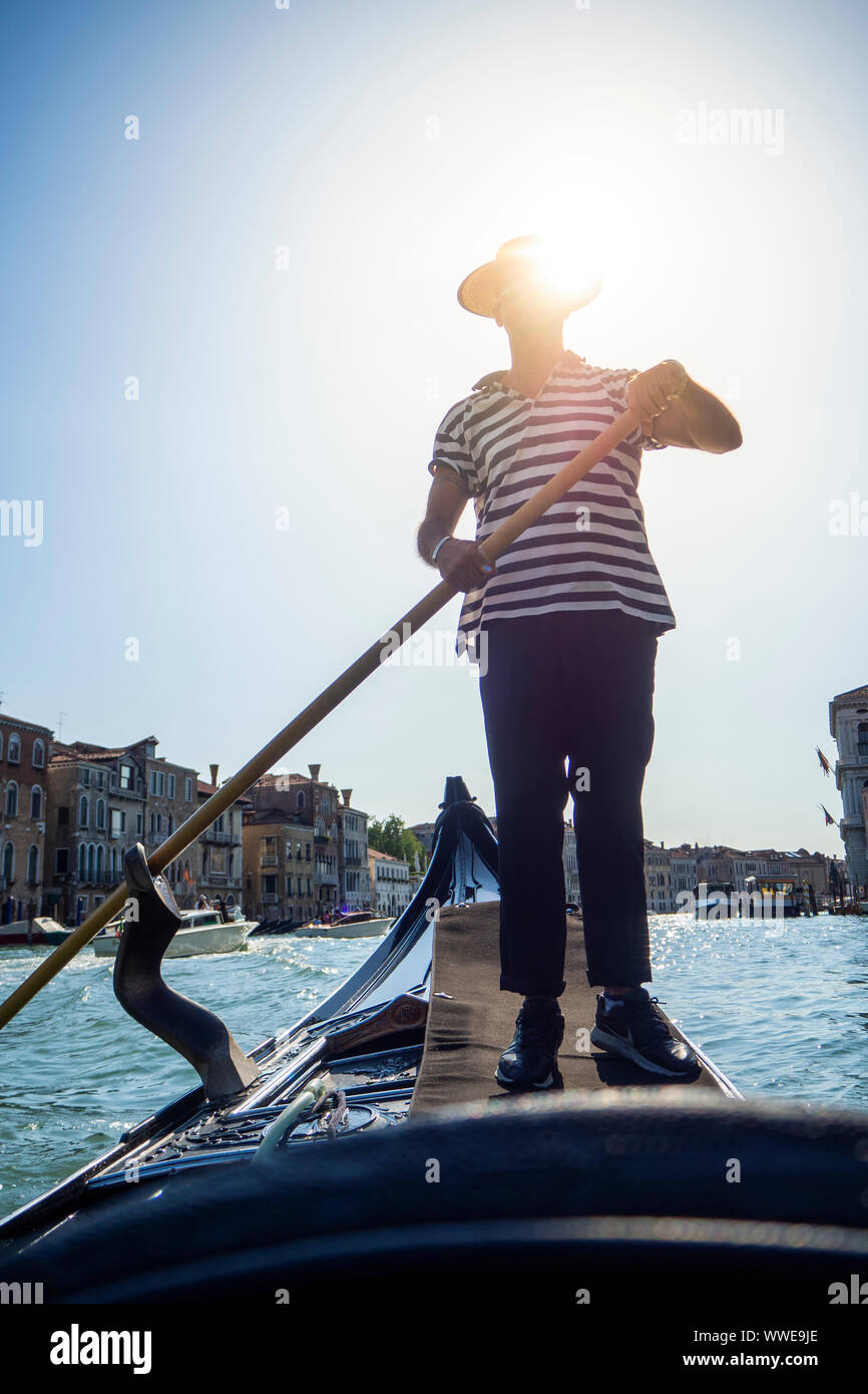 Beautiful view of the Venice canal from the hollow of a bridge railing with some boats in the background Stock Photo