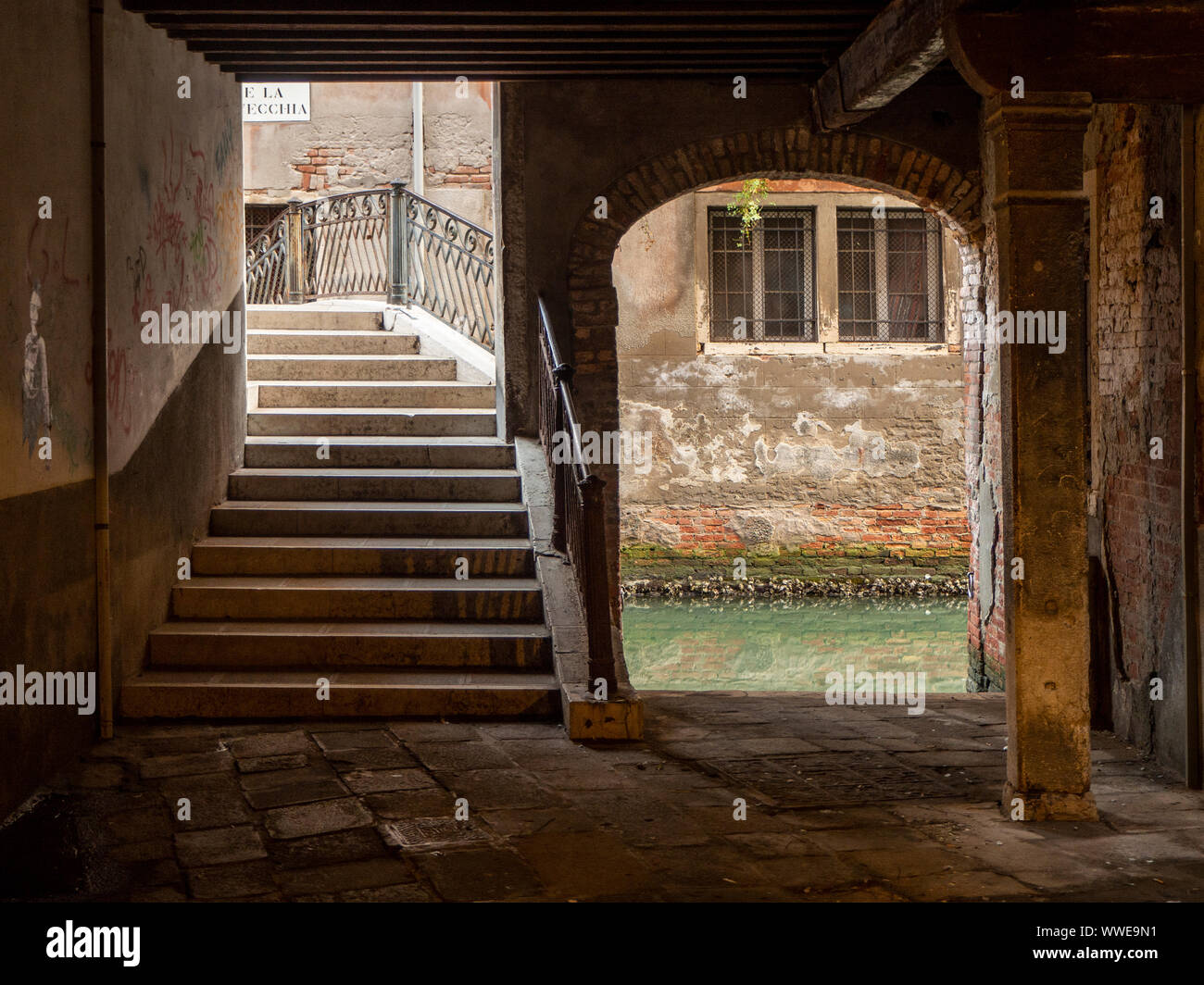 Beautiful alley with access to one of the bridges that cross the canals, the charm of Venice. Stock Photo