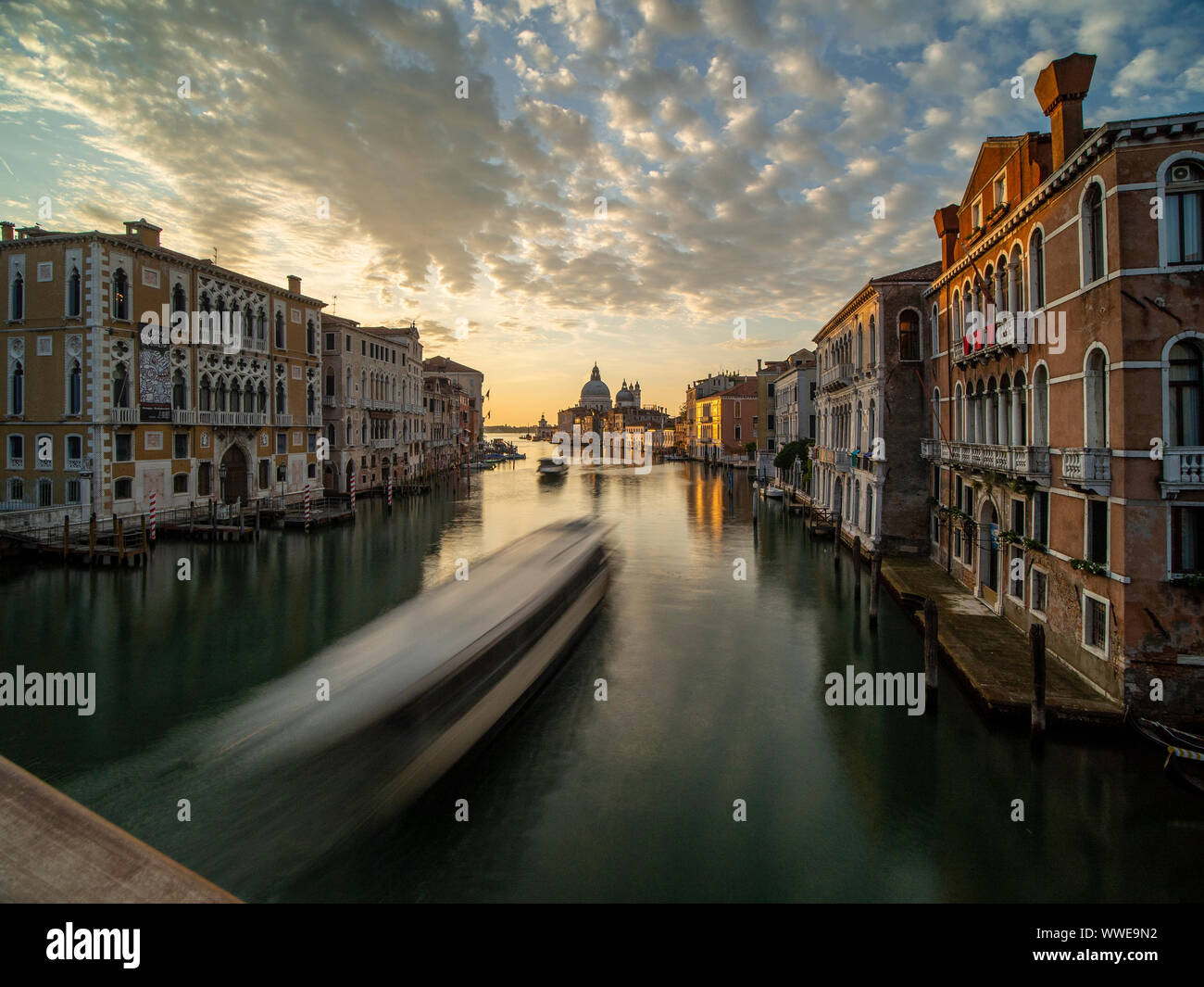 Beautiful view of the sunrise from the bridge of the academy on the Grand Canal with the Basilica of Santa Maria della Salute in the background. Venic Stock Photo
