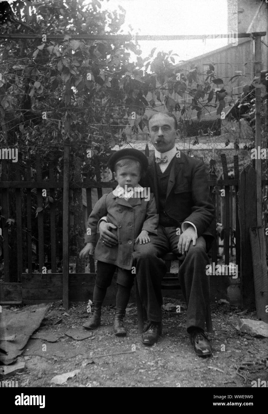 AJAXNETPHOTO. 1889-1900 (APPROX). FRANCE (EXACT LOCATION UNKNOWN.). - FAMILY SNAPSHOT - MAN SEATED WITH YOUNG BOY IN FENCED GARDEN ENVIRONMENT. IMAGE FROM ORIGINAL GLASS PLATE NEGATIVE; DATE SOURCE FROM GLASS PLATE BOX LID.  PHOTOGRAPHER:UNKNOWN © DIGITAL IMAGE COPYRIGHT AJAX VINTAGE PICTURE LIBRARY SOURCE: AJAX VINTAGE PICTURE LIBRARY COLLECTION REF:AVL PEO FRA 1889 101 Stock Photo