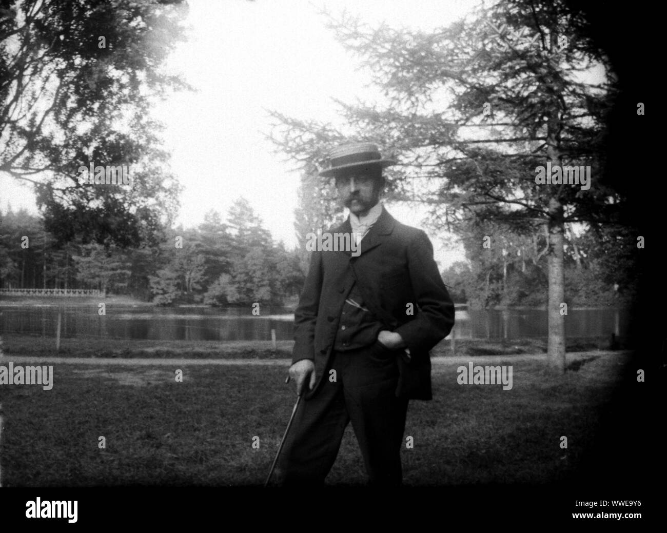 AJAXNETPHOTO. 1889-1900 (APPROX). FRANCE (EXACT LOCATION UNKNOWN.). - FAMILY SNAPSHOT - MAN WEARING BOATER HAT SMARTLY DRESSED IN PARK ENVIRONMENT WITH A LAKE OR POND DISTANT. IMAGE FROM ORIGINAL GLASS PLATE NEGATIVE; DATE SOURCE FROM GLASS PLATE BOX LID.  PHOTOGRAPHER:UNKNOWN © DIGITAL IMAGE COPYRIGHT AJAX VINTAGE PICTURE LIBRARY SOURCE: AJAX VINTAGE PICTURE LIBRARY COLLECTION REF:AVL PEO FRA 1889 107 Stock Photo
