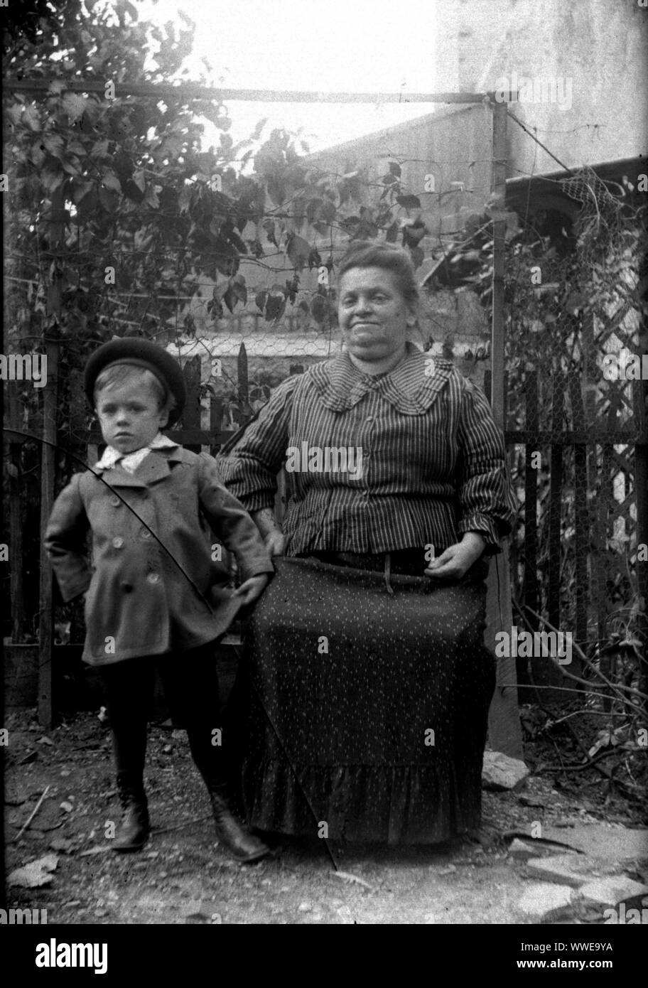 AJAXNETPHOTO. 1889-1900 (APPROX). FRANCE (EXACT LOCATION UNKNOWN.). - FAMILY SNAPSHOT - WOMAN SEATED WITH YOUNG BOY IN FENCED GARDEN ENVIRONMENT. IMAGE FROM ORIGINAL GLASS PLATE NEGATIVE; DATE SOURCE FROM GLASS PLATE BOX LID.  PHOTOGRAPHER:UNKNOWN © DIGITAL IMAGE COPYRIGHT AJAX VINTAGE PICTURE LIBRARY SOURCE: AJAX VINTAGE PICTURE LIBRARY COLLECTION REF:AVL PEO FRA 1889 110 Stock Photo