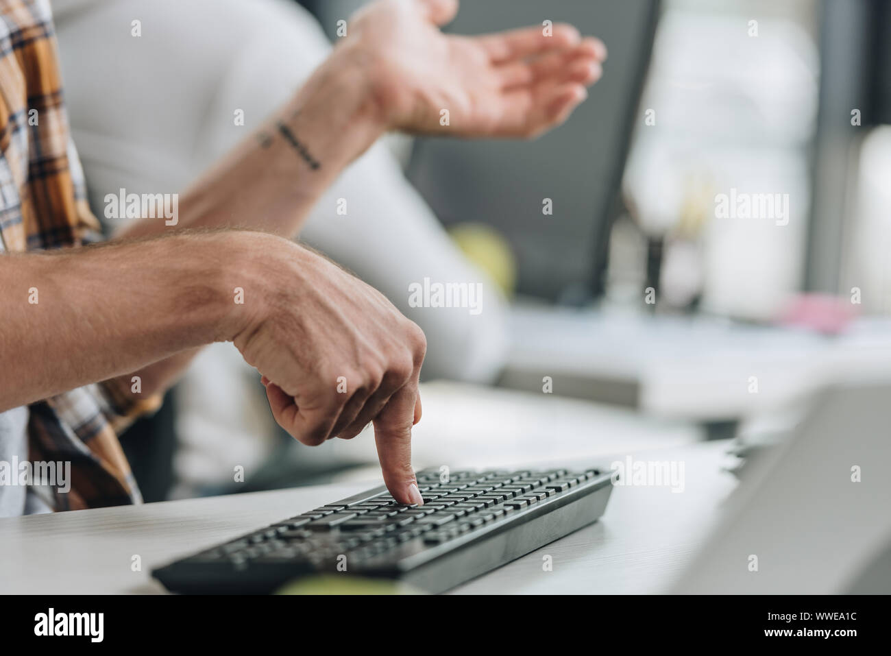 cropped view of programmer gesturing while pressing key on keyboard Stock Photo