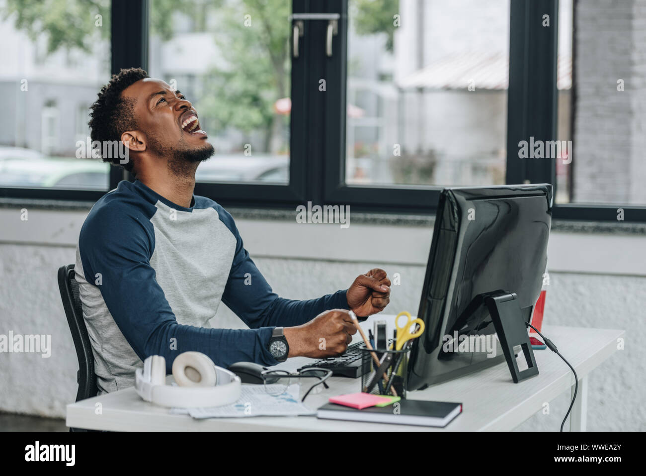 angry african american programmer gesturing while sitting at workplace ...