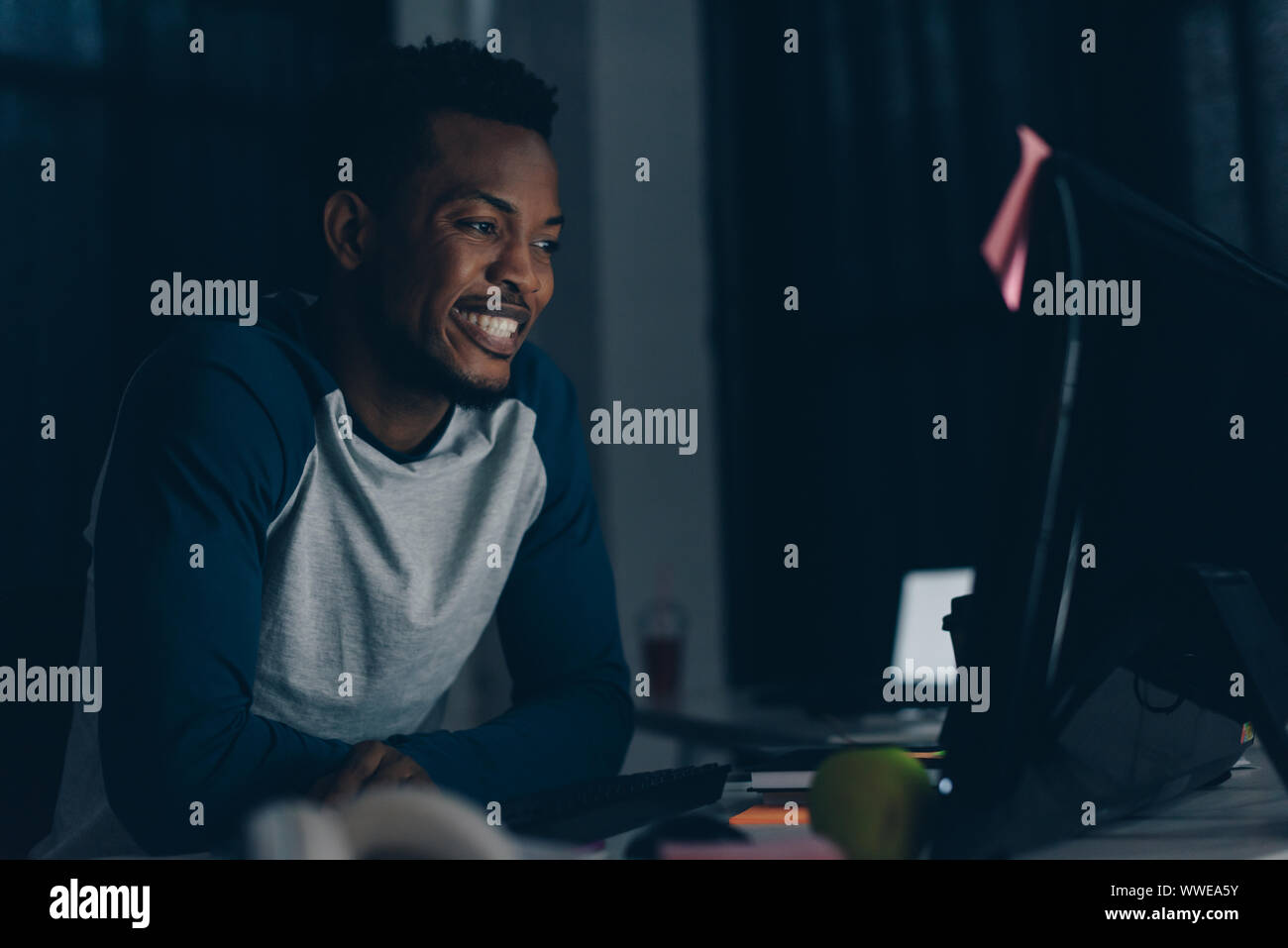 cheerful african american programmer smiling while looking at computer monitor Stock Photo