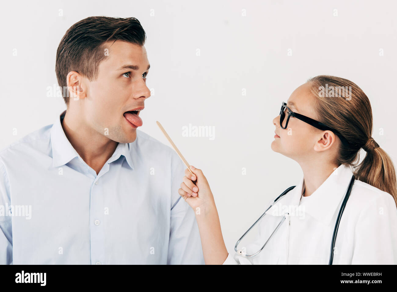 patient and kid in doctor costume holding medical spatula isolated on
