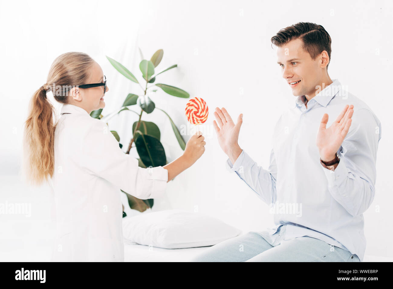 child in doctor costume giving patient candy in clinic Stock Photo Alamy