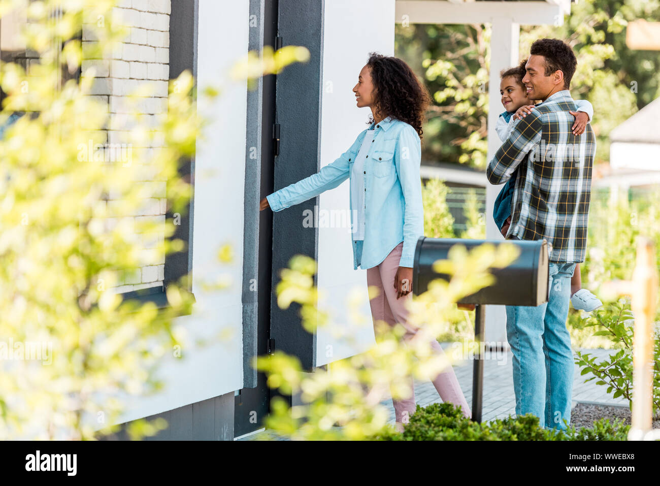 selective focus of african american family walking into new house while  father holding kid Stock Photo - Alamy, image size:1300x957