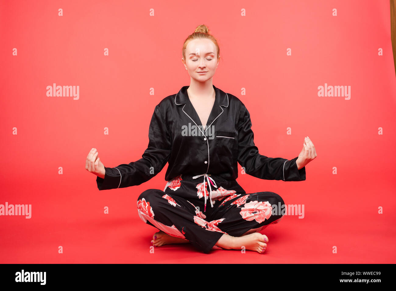 Young girl sitting on floor and meditating with closed eyes Stock Photo ...