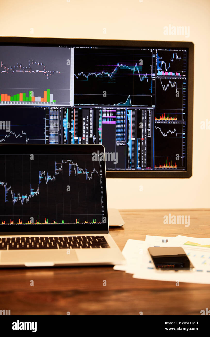 laptop and computer with charts and graphs, documents and smartphone on table Stock Photo