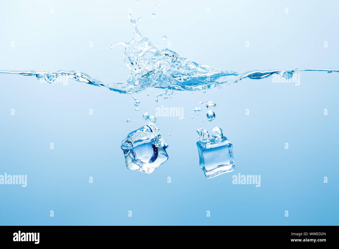 pure water with splash and ice cubes on blue background Stock Photo - Alamy