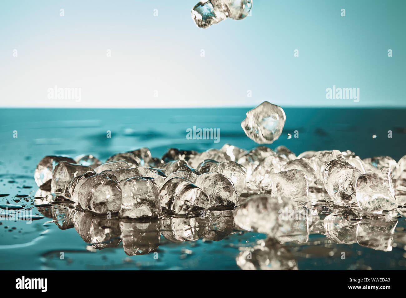melting ice cubes on emerald and white background Stock Photo - Alamy
