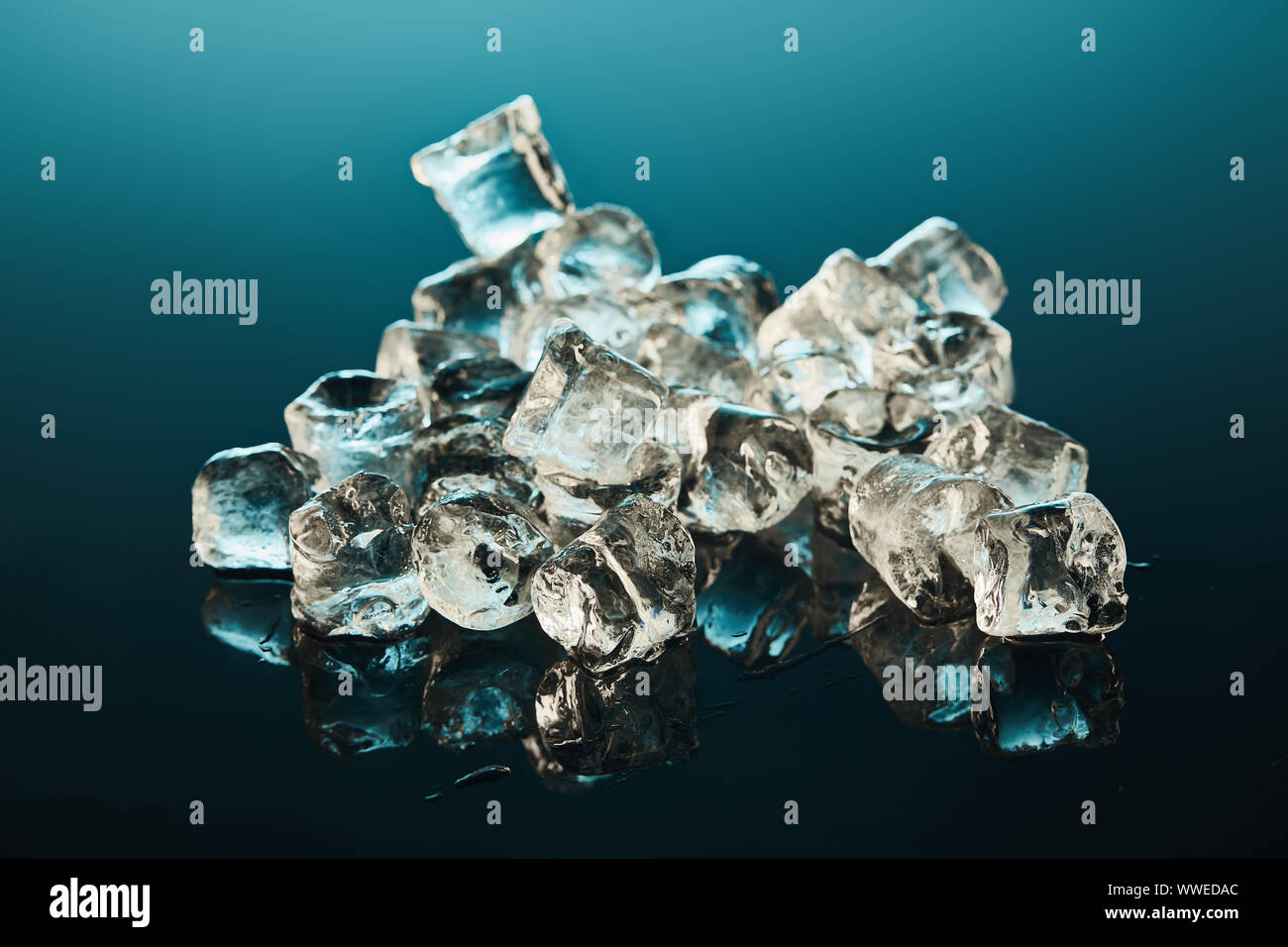 stack of transparent ice cubes on emerald background Stock Photo - Alamy
