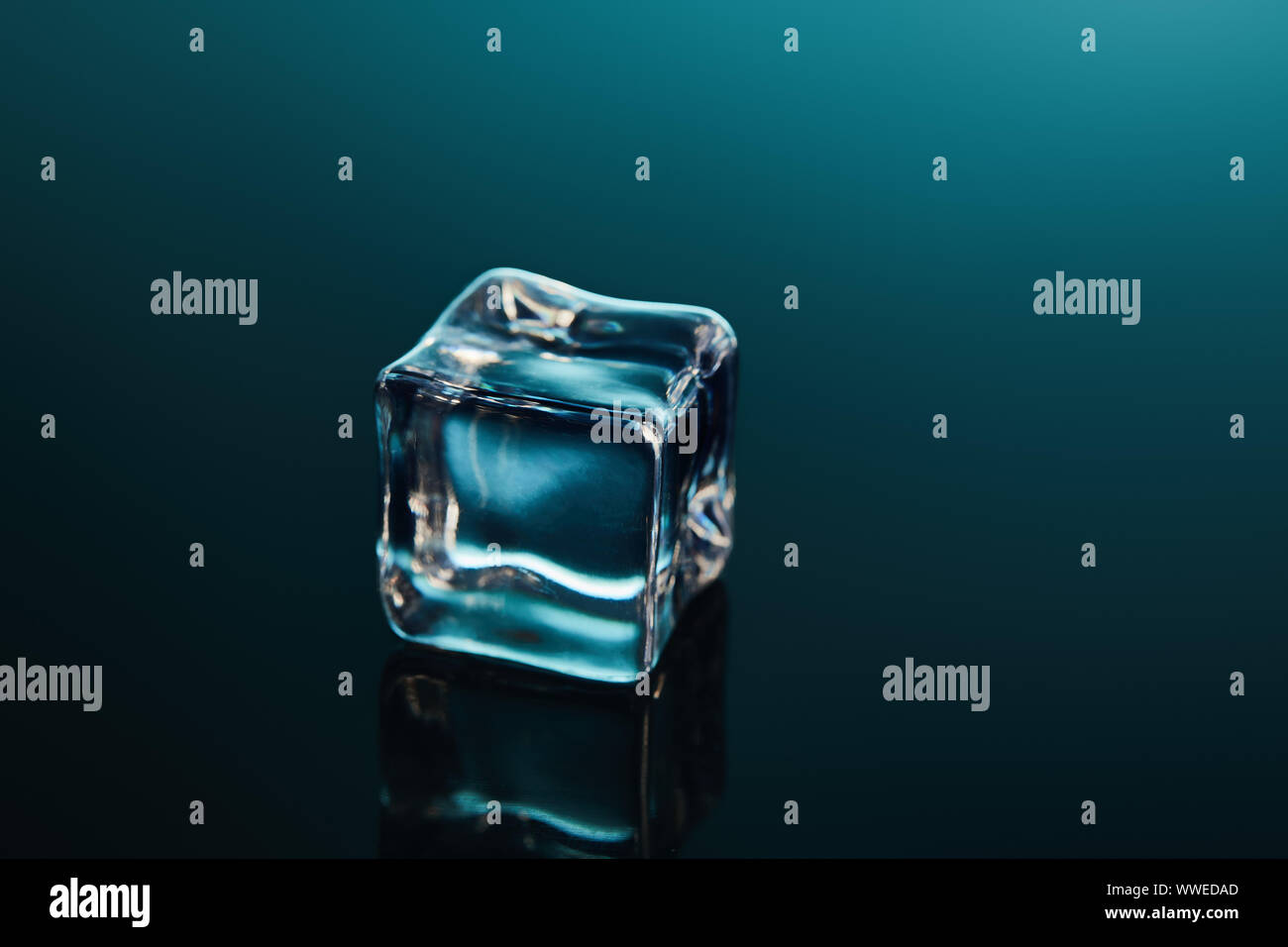 pure transparent ice cube on emerald background Stock Photo - Alamy