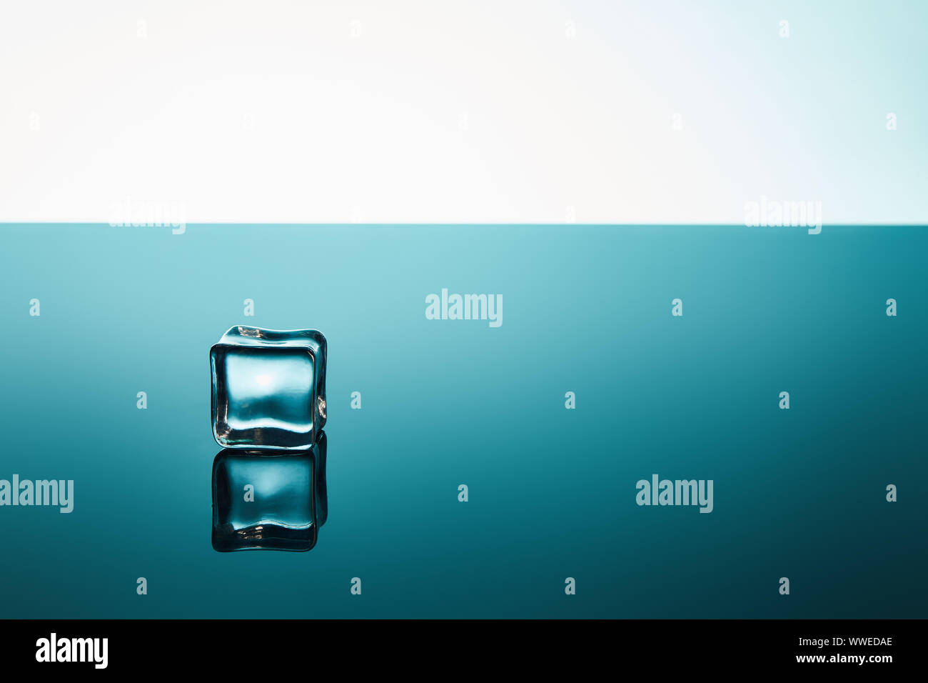 transparent ice cube on emerald and white background Stock Photo - Alamy
