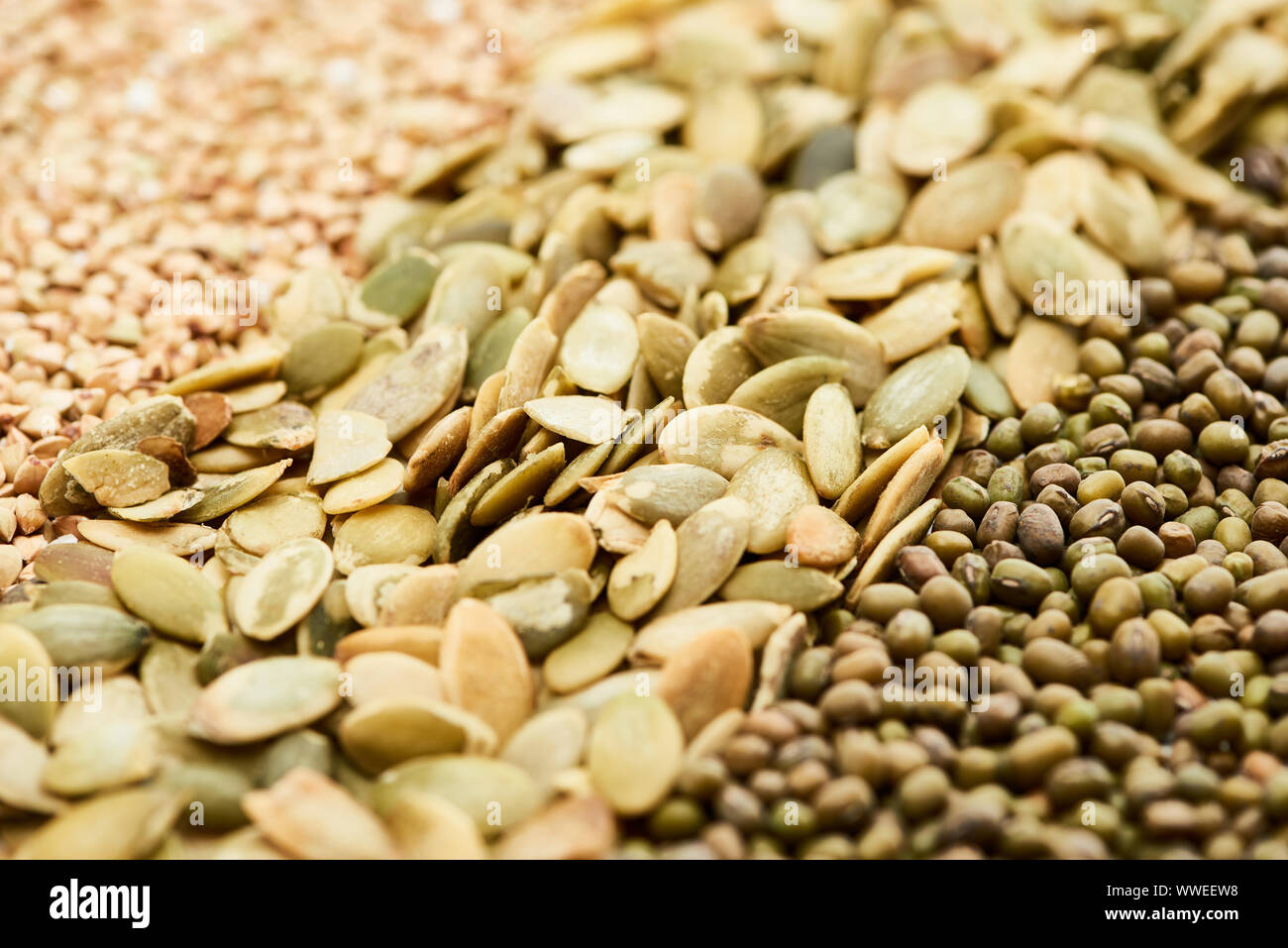 close up view of raw pumpkin seeds near maash and green buckwheat Stock Photo