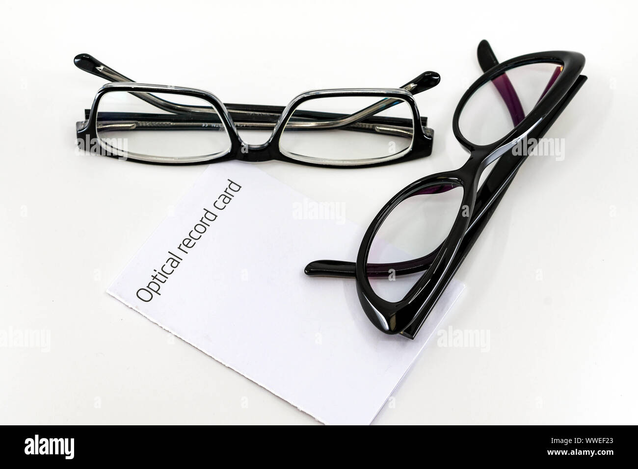 Optical record card with two pairs of black glasses with lenses isolated against a plain white background Stock Photo