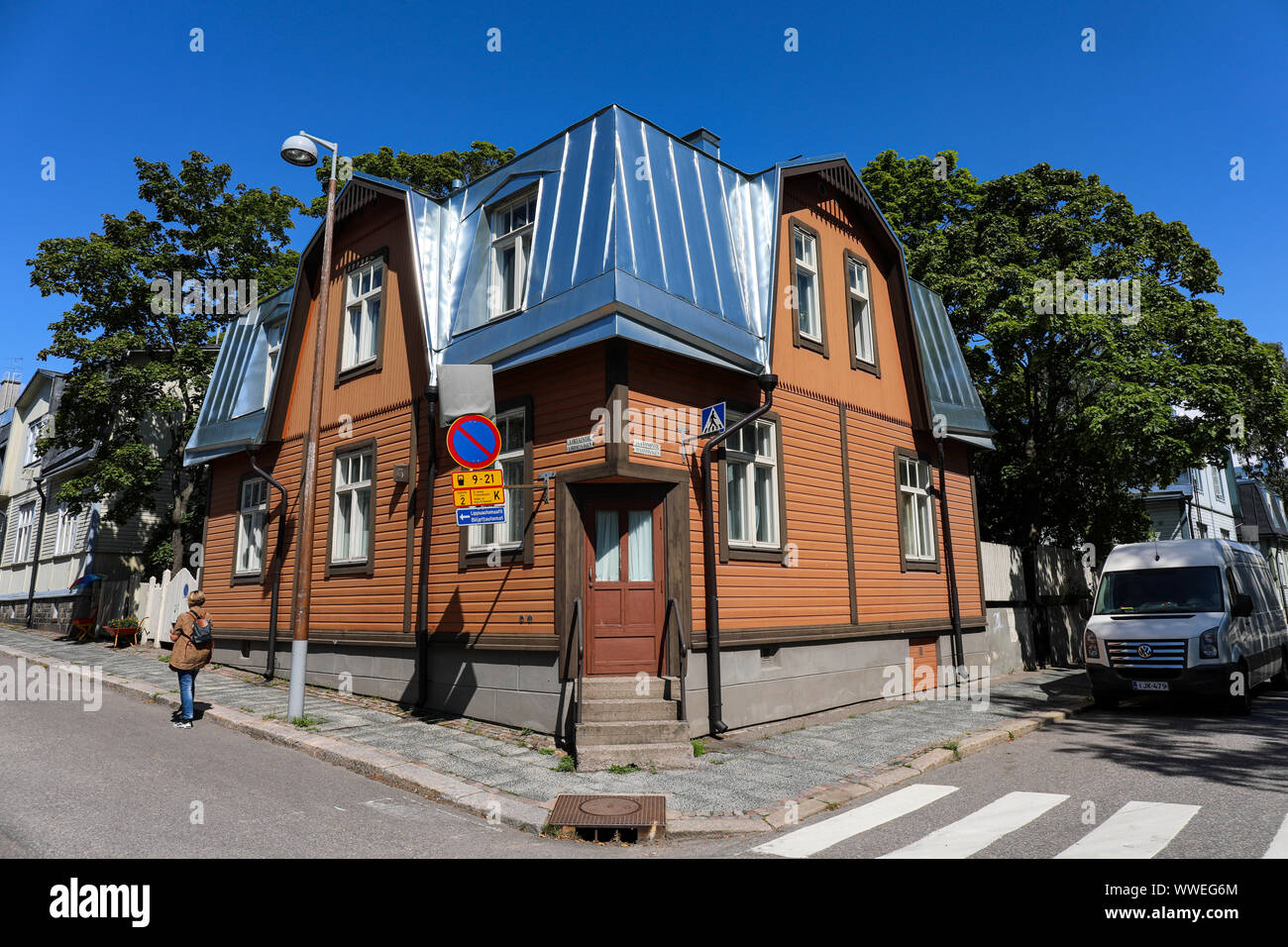 Old wooden building with shiny new metal roof in the corner of Virtaintie and Suvannontie in Helsinki, Finland Stock Photo