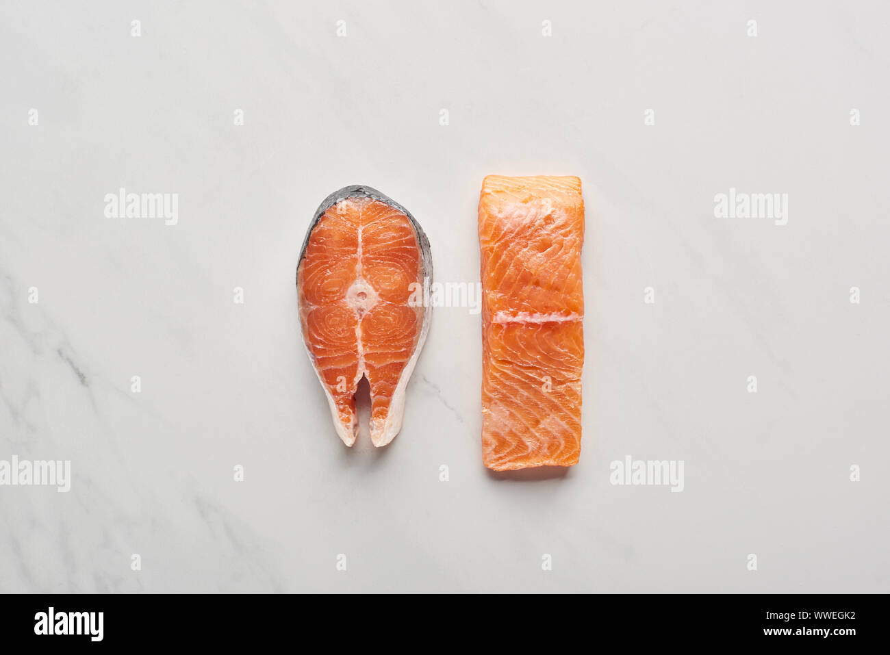 top view of raw fresh salmon steaks on white marble surface Stock Photo ...