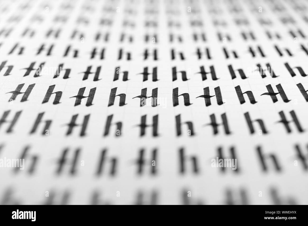 Calligraphy black and white letters H background. Lettering practice writing worksheet. Handwriting symbol filling pattern. Calligraphic letter H lear Stock Photo