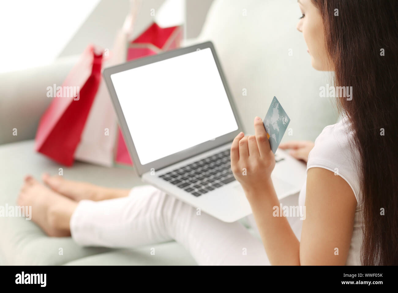 Young woman shopping online with credit card and laptop at home Stock ...