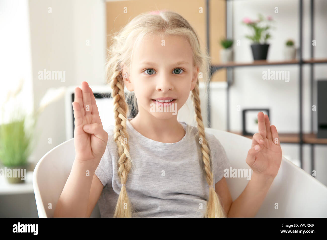 Little deaf mute girl using sign language at home Stock Photo Alamy