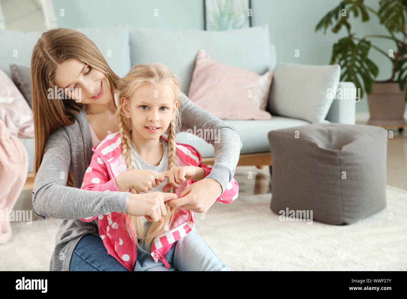 Little deaf mute girl and her mother using sign language at home Stock