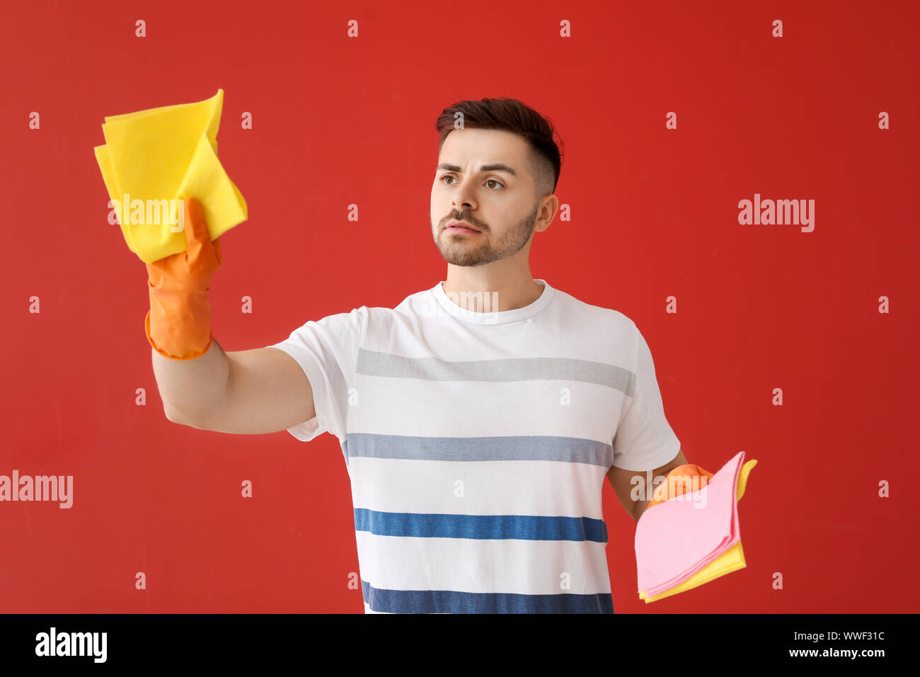 Sad Rags Sad young man with cleaning rags on color background Stock Photo - Alamy