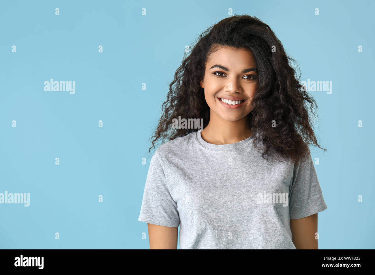 Portrait of cute African-American woman on color background Stock Photo ...